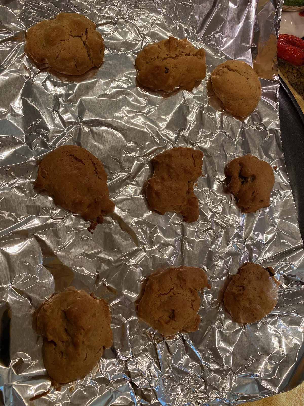 Scoops of brown cookie dough with dark inclusions on foil; likely leads to chunky-cookie batch in 029.