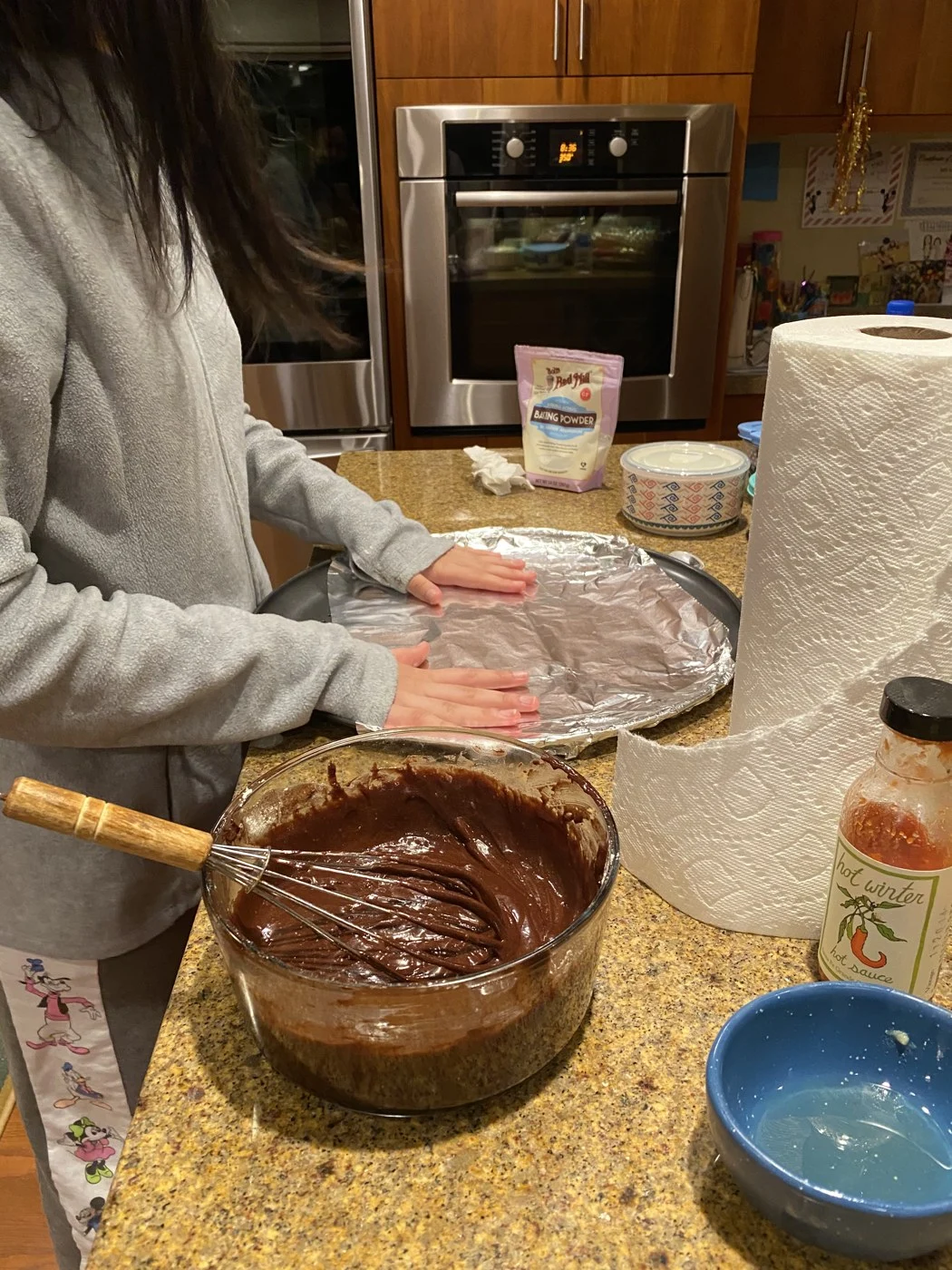 Preparing a foil-lined baking tray beside a bowl of chocolate batter.