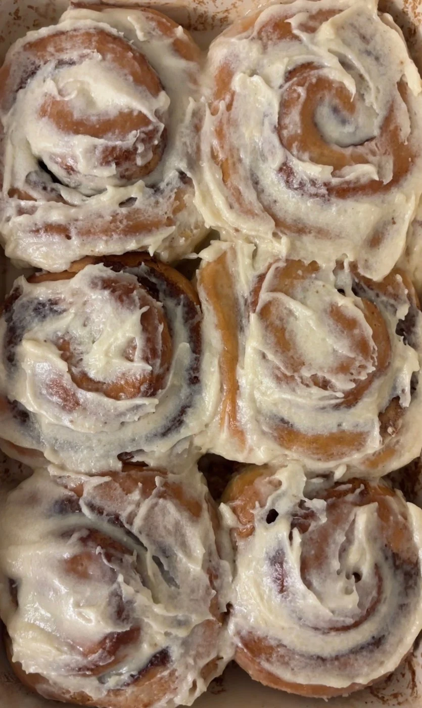 Soft spiral rolls covered in a thick pale frosting.