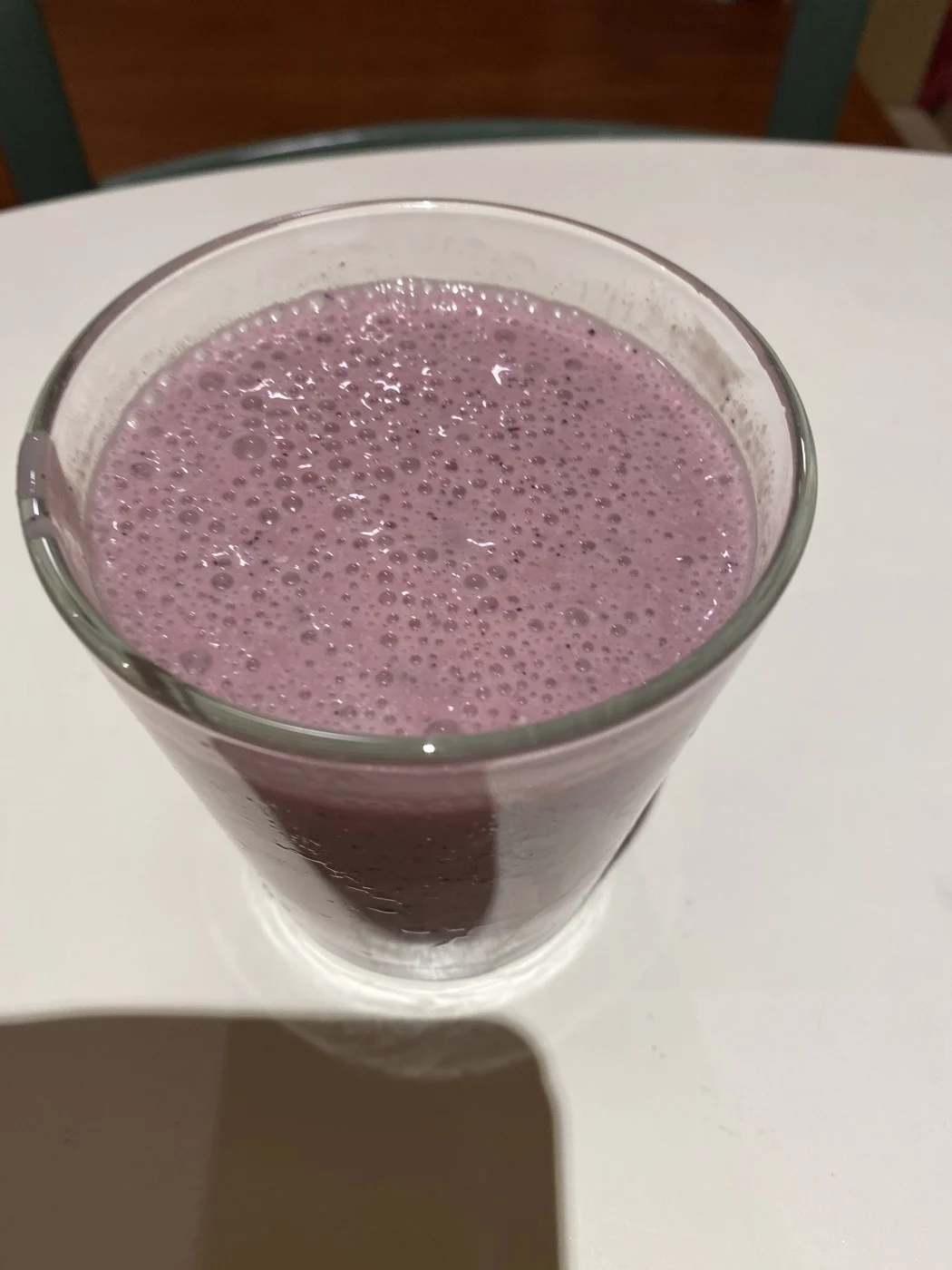 A close overhead view of a purple smoothie with small bubbles.